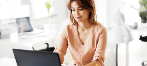Professional woman composing collection letter email from her laptop